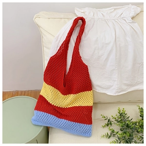 Detail of colorful woven tote bag with red, yellow and blue crochet patterns on a sofa