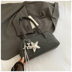 Détail du sac Boston en denim gris avec breloque étoile argentée et nœud décoratif