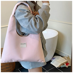 Pink minimalist tote bag detail showing the smooth leather texture and brand label