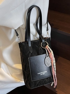 Sac bandoulière vintage noir avec texture plissée et breloque de tennis élégante