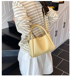 Détail de la texture tissée et de la boucle en métal du sac seau mode de couleur crème