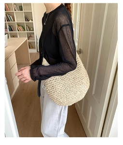 Beige woven straw tote bag shown on model with chic casual outfit for summer styling