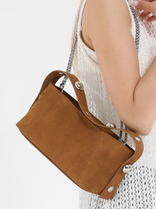 Brown suede underarm baguette bag with silver studs and chain strap on shoulder