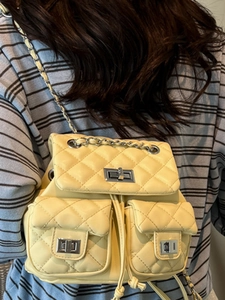Chic yellow quilted backpack featuring classic diamond stitching and chain straps