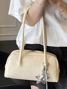 Sac Boston tissé crème élégant avec pendentif étoile argentée porté par un mannequin