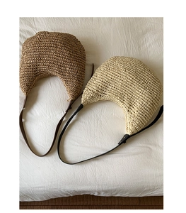 Detailed close-up of woven paper straw shoulder bags in tan and beige colors