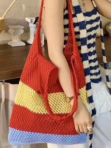 Large knit beach tote bag featuring vibrant red, yellow, and blue striped crochet patterns