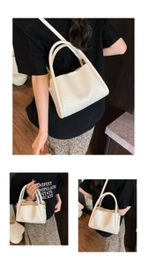 Détail de la texture en cuir tressé blanc cassé et de l'élégante boucle en métal doré