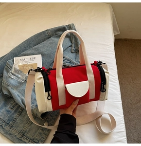 Detail of red and white canvas Boston bag with side pocket and YOU JI BEAR logo tag