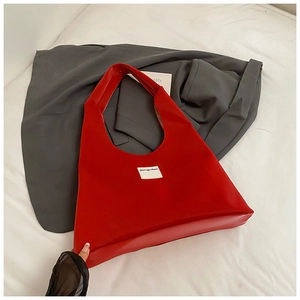 Detail of red velvet tote bag with branded white cloth label on high-quality fabric