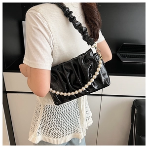Détail du sac bandoulière en cuir verni plissé noir avec chaîne de perles élégante