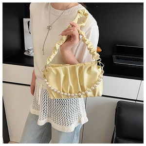 Détail du sac nuage plissé jaune clair avec une élégante grande chaîne de perles