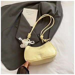 Detail of light yellow pleated leather hobo bag with pearl lace butterfly pendant