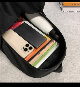 Spacious interior of black waterproof backpack showing laptop and books storage