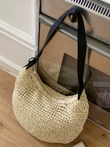 Chic beige straw woven crescent shoulder bag with black strap for summer beach vacation