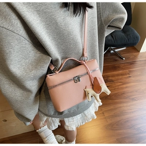 Borsa rosa a scatola con trama litchi indossata a tracolla con ciondolo a cavallo