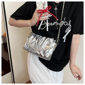 Détail du sac à bandoulière argenté plissé avec perles décoratives et chaîne en métal