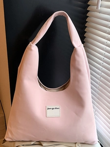 Pink velvet hobo bag with minimalist square label shown in natural side lighting