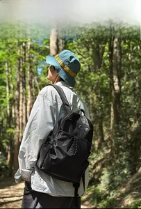 Outdoor view of lightweight waterproof black nylon backpack with multi-pocket design on model