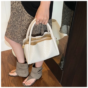 Détail d'un sac seau blanc tissé avec pochette intérieure zippée et texture souple