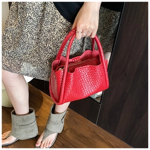 Détail du sac seau tressé rouge avec motif à carreaux et pochette intérieure zippée