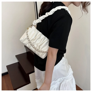 Détail du sac à bandoulière plissé blanc cassé avec chaîne en perles et sangle