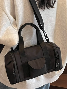 Minimalist black nylon Boston cylinder crossbody bag with multiple zipper pockets