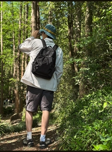 Waterproof nylon backpack in outdoor forest setting with multi-pocket design for hiking