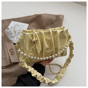 Détail du sac nuage plissé jaune avec chaîne en perles et texture de cuir sophistiquée