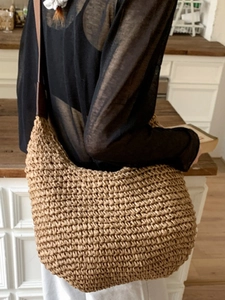 Minimalist straw hobo bag with brown leather straps for elegant seaside summer beach travel