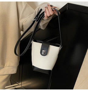 Close-up of litchi grain leather bucket bag with silver buckle and black trim details