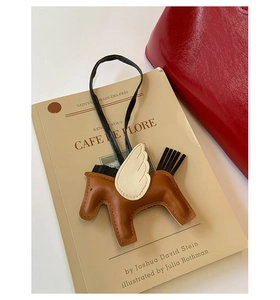 Détail d'un charme de sac pégase en cuir créatif avec corps brun et ailes blanches