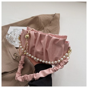 Détail du sac nuage plissé rose avec chaîne de perles et bandoulière froncée chic