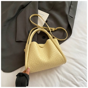 Détail du sac seau jaune tissé montrant la texture artisanale et les finitions