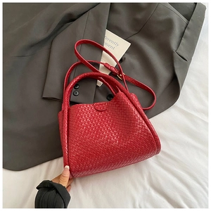 Détail du sac panier tressé rouge montrant la texture fine et la bandoulière réglable
