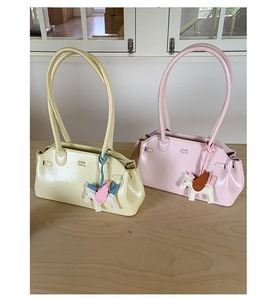 Détail de sacs bowling jaune et rose pastel avec breloques cheval et doubles anses