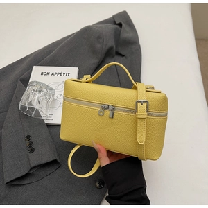 Dettaglio ravvicinato della borsa gialla in pelle a grana con eleganti finiture in argento