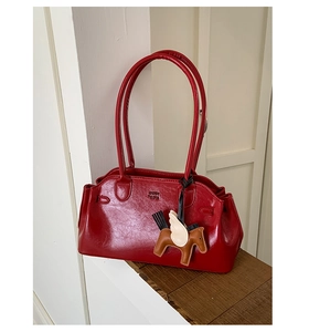Vue détaillée du sac bowling en cuir brillant rouge foncé avec pendentif cheval