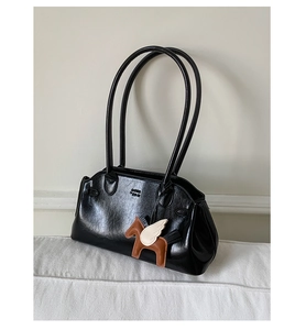 Détail du sac bowling en cuir verni noir avec breloque Pégase et logo embossé