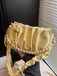 Sac à main nuage plissé jaune clair élégant avec chaîne en perles pour femme en décor de vie