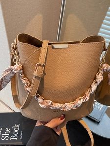 Minimalist khaki bucket bag with lychee texture and silk scarf wrapped chain handle