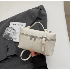 Dettaglio ravvicinato della pelle bianca martellata e hardware argento della borsa box