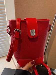 Fashionable red litchi grain bucket bag with silver metal clasp and adjustable strap