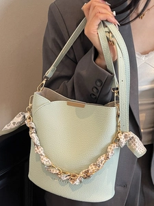 Chic mint green bucket bag with lychee texture and silk scarf handle for modern women
