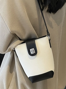 Minimalist black and white bucket bag with pebble texture and silver buckle for women