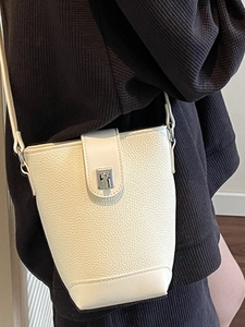 Chic cream-colored bucket bag in pebbled leather with silver buckle for crossbody style