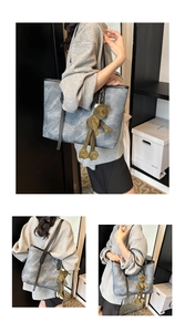 Detail of grey marble tote bag with black straps and green frog plush charm accessory