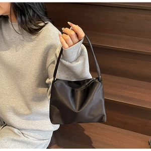 Détail d'un sac à bandoulière chic en strass noir avec finition satinée et fermeture éclair