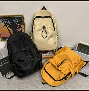 Three multi-pocket nylon backpacks in beige, black, and yellow for daily travel