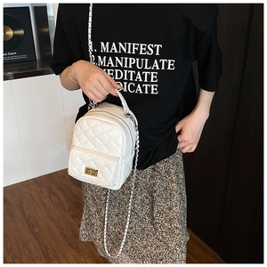 Detailansicht der gesteppten weißen Beuteltasche mit goldenem Drehverschluss und Kette
